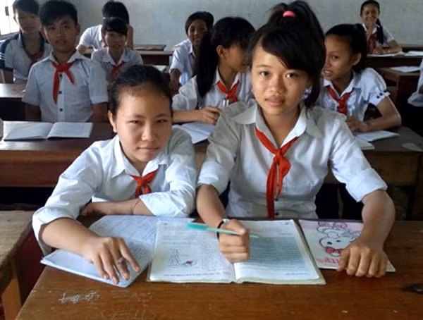 Hitting the books: Nga (right) helps her friend, Gai, with her study at school. - Photo baomoi.com