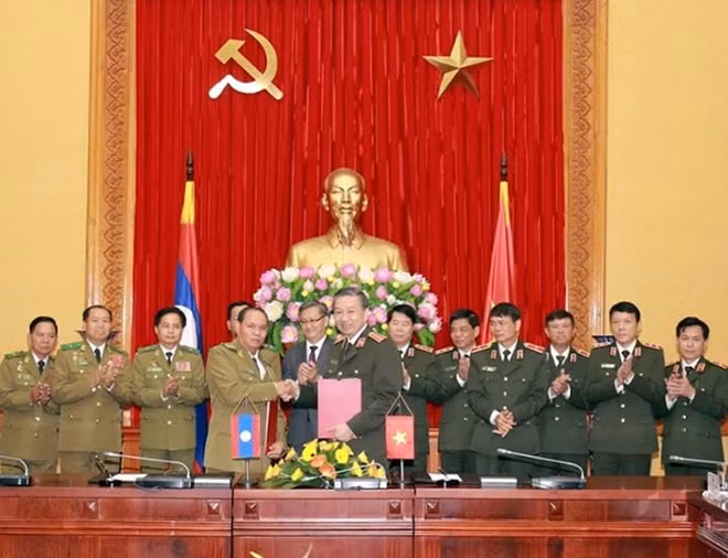 Minister To Lam and Minister Vilay Lakhamphong witness the signing of cooperation agreements.