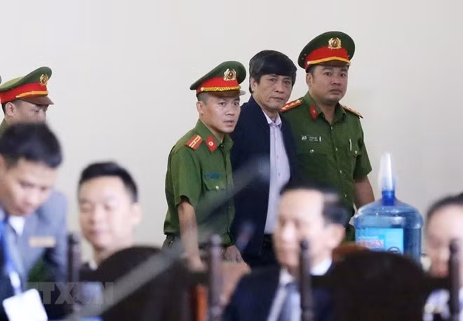 Nguyen Thanh Hoa (standing, centre), former Director of the MoPS’s Hi-tech Crime Police Department, is brout to the trial on November 12 (Photo: VNA)