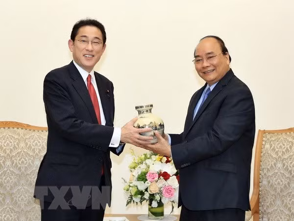 PM Nguyen Xuan Phuc (R) presents a souvenir to Fumio Kishida, Chairman of the Policy Research Council of the Liberal Democratic Party of Japan (Photo: VNA)