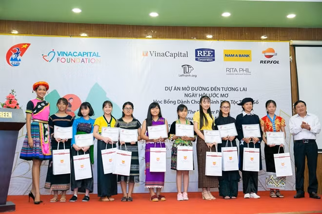 Miss H'Hen Niê presenting scholarships to ethnic minority girls.