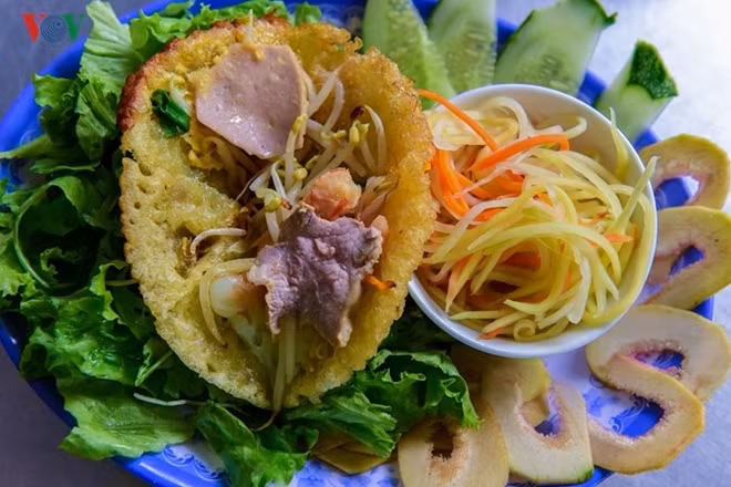Banh Khoai (pancake). It is wrapped in mustard leaf, lettuce leaves or rice paper, and stuffed with variety of herbs like mint and basil and served with a sweet and sour mixed sauce.
