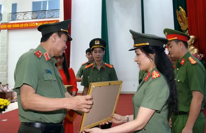 Deputy Minister Le Tan Toi presents certificate to leader of the Public Security Department of Information and Communication.
