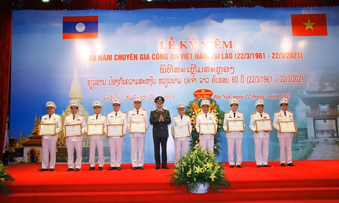 Minister To Lam awards Certificates of Merit from the Vietnamese Ministry of Public Security to Vietnamese public security experts in Laos with outstanding achievements.