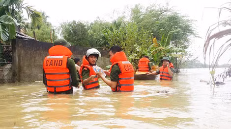 Police officers evacuate people from flooded area.