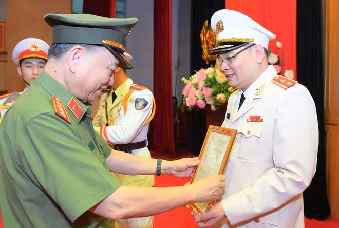 Under the authority of the State President, Minister To Lam hands the rank promotion decision to Lieutenant General To An Xo.