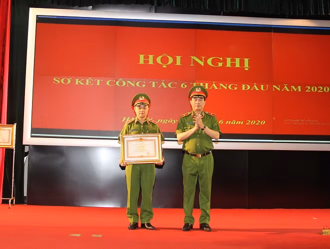 under the authority of the Prime Minister, Deputy Minister Le Quoc Hung presents the Prime Minister's Certificate of Merit to the Lieutenant Lieutenant General Pham Quoc Cuong, Commander of the Mobile Police High Command.
