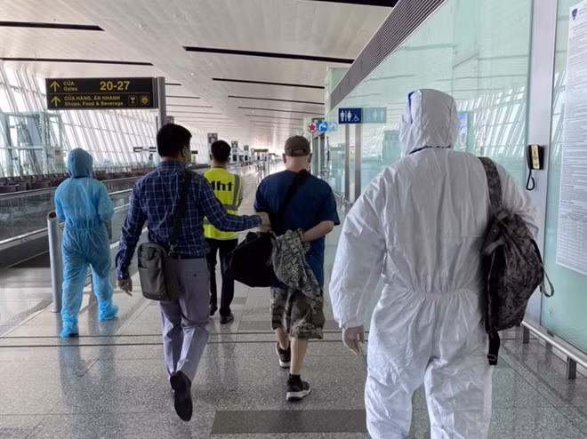 One figitive being escorted at Noi Bai airport.