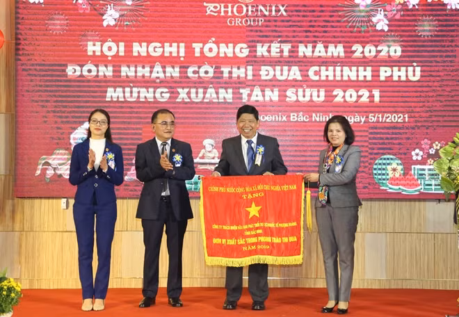 Under the authorization of the Prime Minister, Ms. Nguyen Huong Giang, Chairwoman of the Bac Ninh Provincial People's Committee presents the Government Emulation Flag to Phoenix Group.