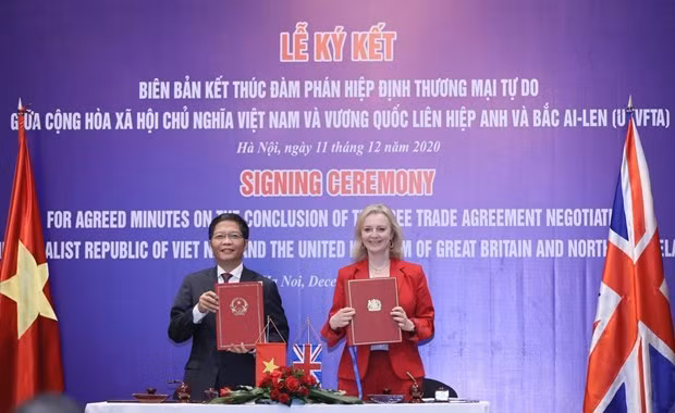 Minister of Industry and Trade Tran Tuan Anh and UK Secretary of State for International Trade Elizabeth Truss sign the minutes on the conclusion of negotiations over the UKVFTA on December 11. Photo: VNA