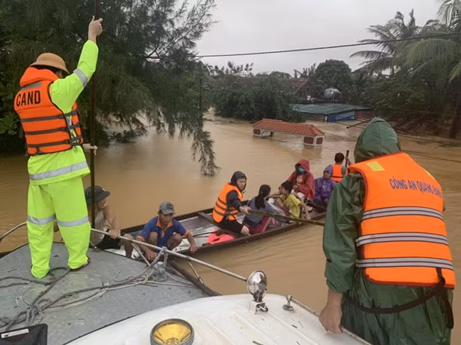 Quang Binh policemen use small boats to enter the submerged areas and evacuate people to safer places.