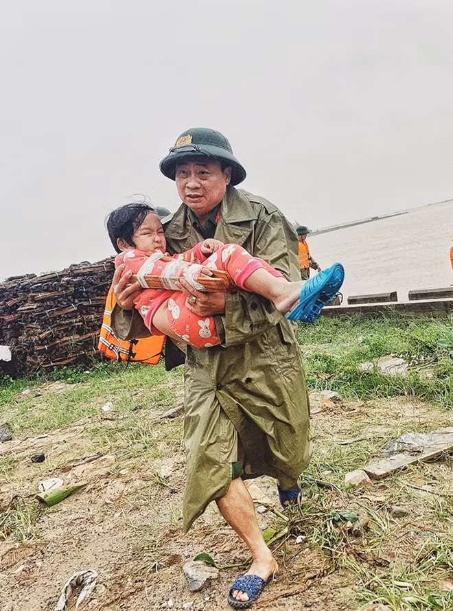 Colonel Le Van Hoa, Head of the Ba Don Town Police Station (Quang Binh) takes a baby with a broken arm from the flooded area to the hospital.