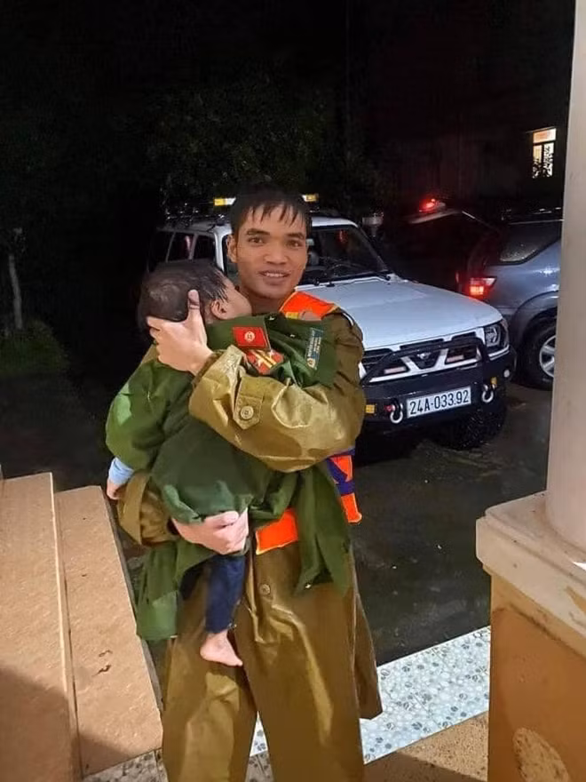 A police soldier takes off his uniform to cover a 2-year-old baby, one of the 18 victims of a traffic accident in Bo Trach, Quang Binh province.