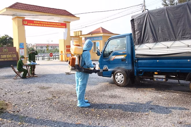 A staff sprays disinfectants to sterilize a vehicle at a prison's gateway.