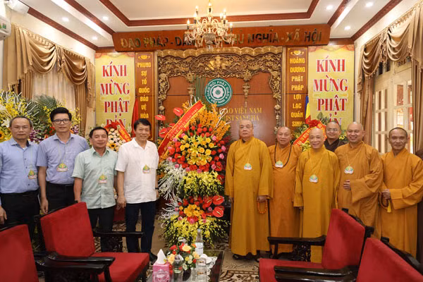 On behalf of the Ministry of Public Security, Deputy Minister Luong Tam Quang presents congratulation flowers to representatives of the Vietnam Buddhist Sangha on the occasion of Buddha's Birthday.