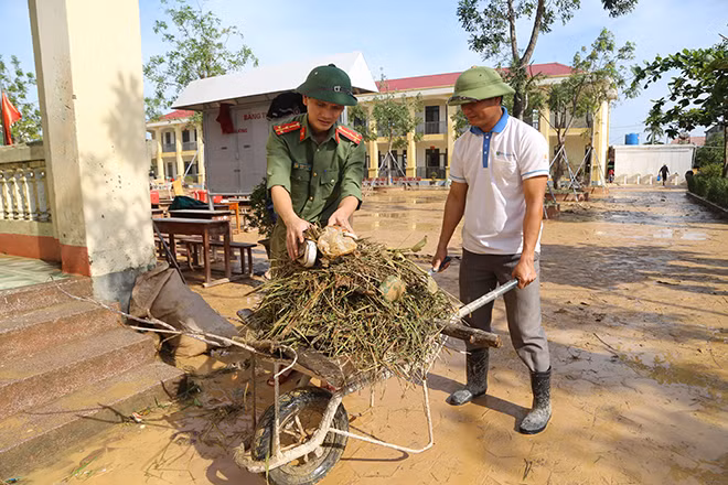 Police officers join hand with teachers to cleanup school facilities.