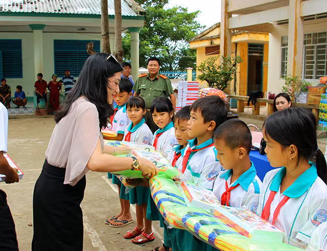 Ms.Dang Thai Hien's family, owner of Ghe Go restaurant in Can Tho presenting notebooks and life jackets to students.