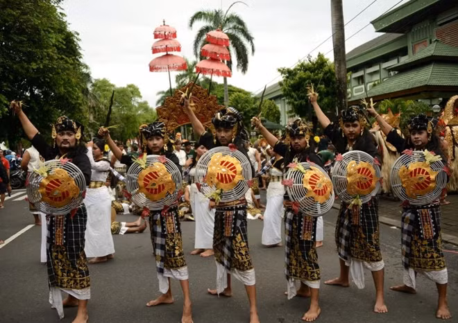 Balinese take part in a cultural parade during a festival