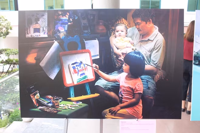 TEACHING DAUGHTER HOW TO DRAW Photo: Nguyen Thanh Tung Daddy's joy after work is to be with his family and to teach his daughter how to draw.