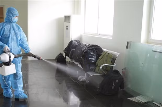 A medical worker disinfects luggage of people entering Vietnam illegally (Source: VNA)