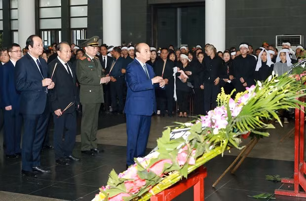 Prime Minister Nguyen Xuan Phuc (front) at the funeral for three police officers. (Photo: VNA)