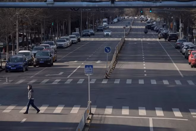A man wearing a face mask crosses a road, as the country is hit by an outbreak of the novel coronavirus, in Beijing, China February 15, 2020. REUTERS/Stringer