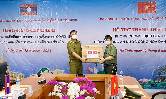 Lieutenant General Nguyen Thanh Son hands over medical supplies from the Vietnamese MPS to the Lao side.