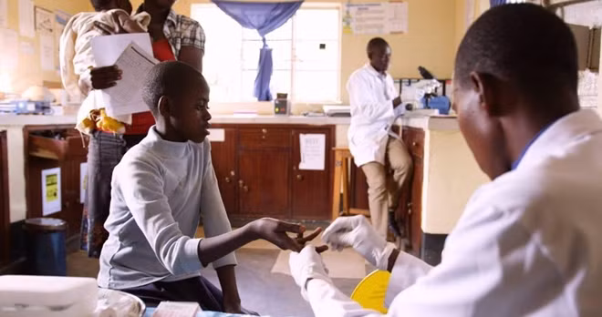 A refugee receives a medical checkup at a clinic in Uganda. Thanks to its cloud-powered app, Medical Teams International can now upload patient notes from this visit, compile it with other patient data, and analyze it for trends that could indicate an upcoming outbreak.