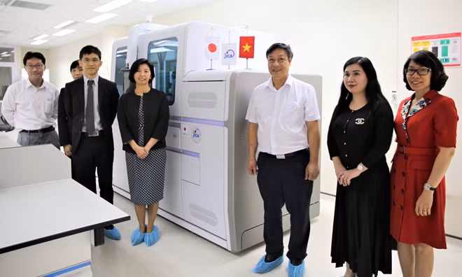 Ms. IWAMA Nozomi, Senior Representative of JICA Vietnam Office (in the middle left, next to the system) presented Automatic PCR system Cobas 6800 to Dr. Pham Ngoc Thach, Director of NHTD (in the middle right, next to the system) with the witness of representatives of Ministry of Health and Embassy of Japan to Vietnam.