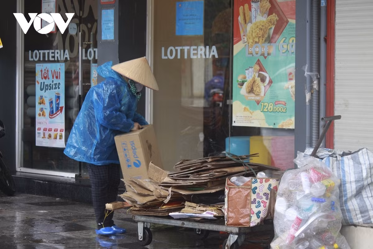 A garbage collector continues with her daily work despite the harsh weather.