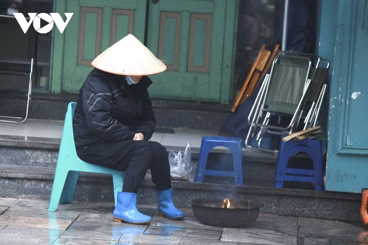 A worker burns fire to stay warm amid the frosty weather.