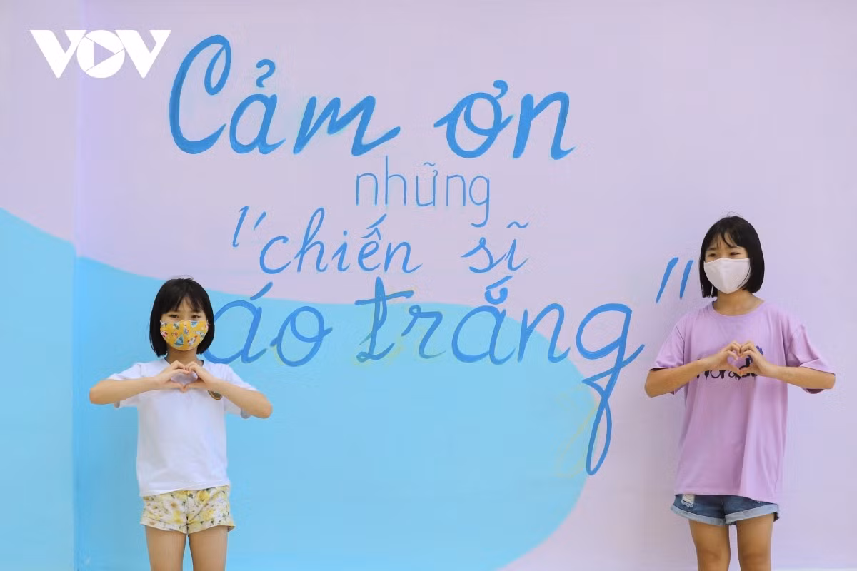 Children take photos alongside the mural paintings, sending their sincere thanks to healthcare workers and soldiers who work hard all day in the country’s ongoing fight.