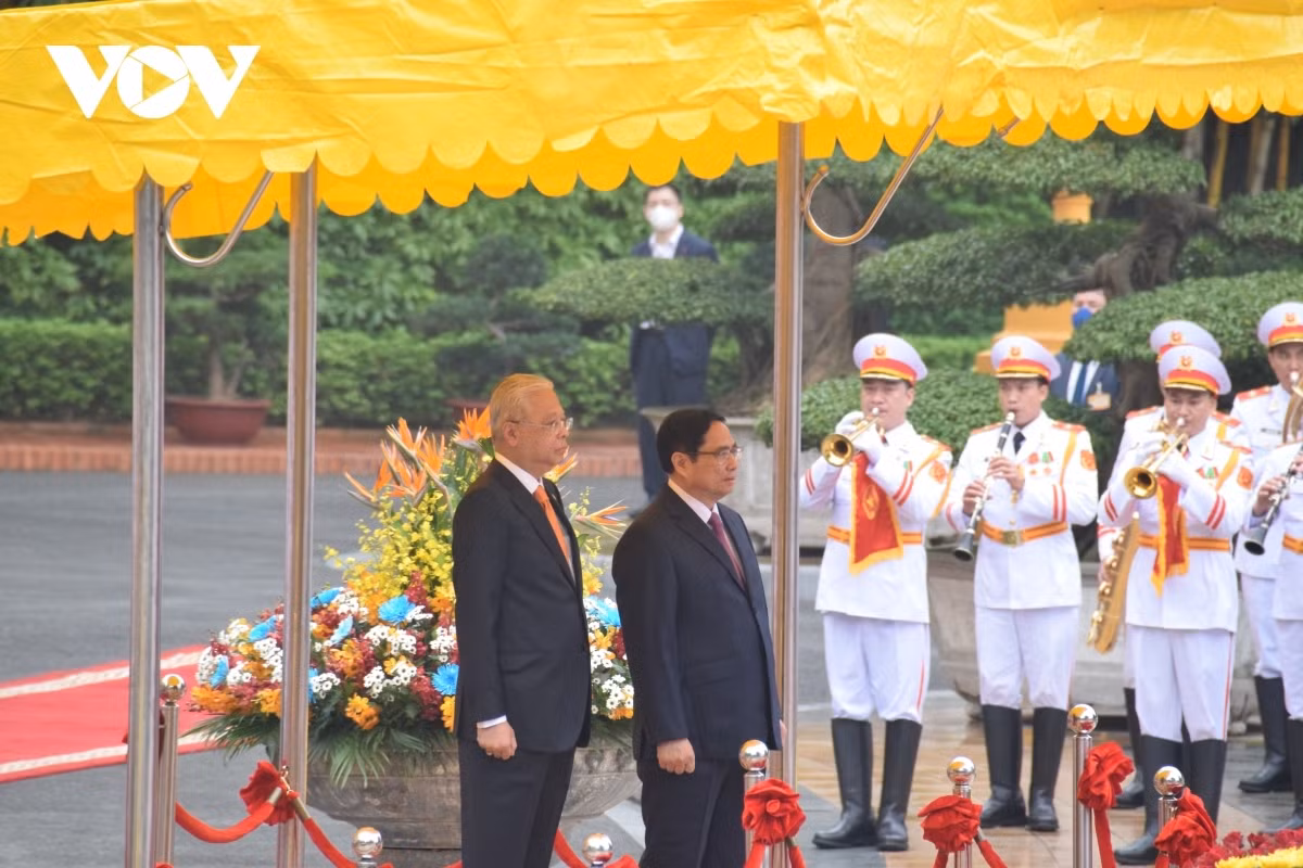 PM Chinh invites his Malaysian counterpart to step on the podium while military bands play the national anthems of both nations.