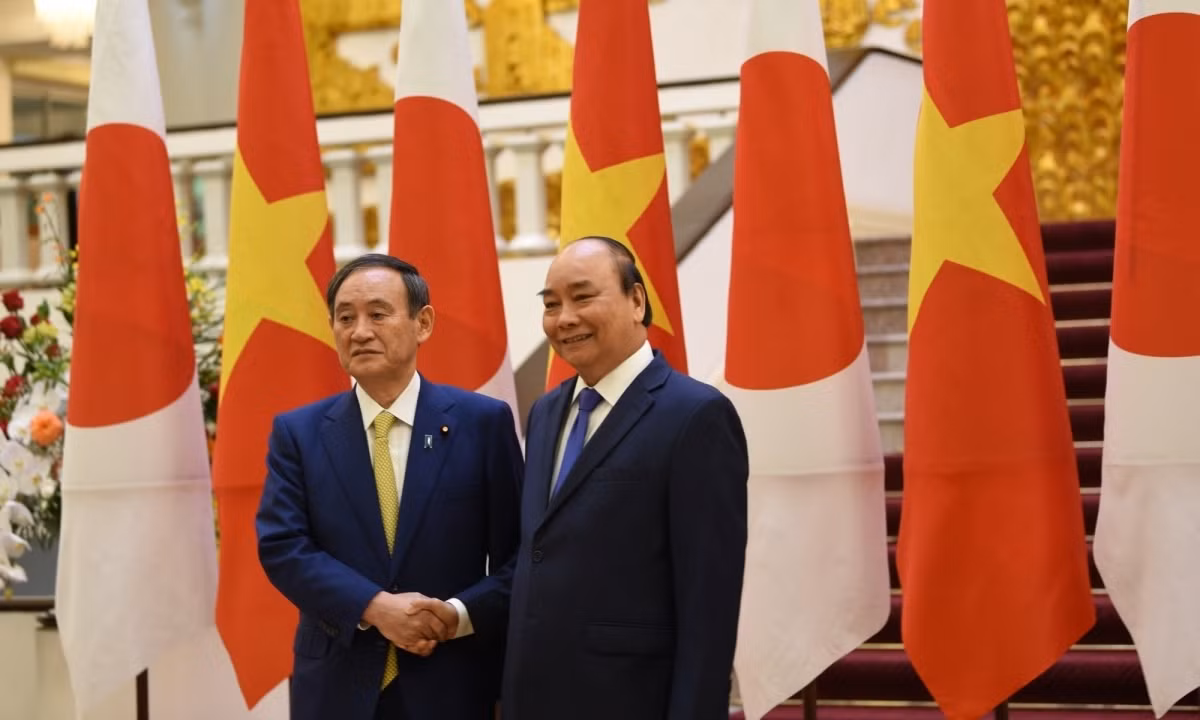 Prime Minister Nguyen Xuan Phuc (R) welcomes his Japanese counterpart Prime Minister Yoshihide