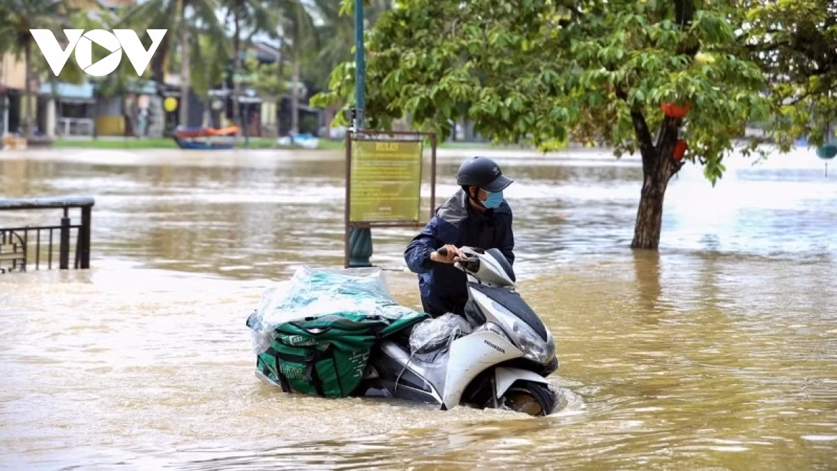 A shipper struggles to travel amid flooding in the region causing his motorbike to break down.