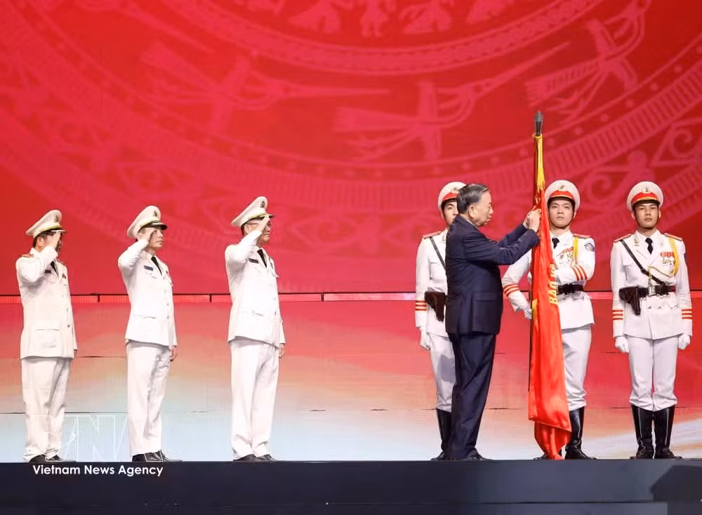 Party General Secretary and State President To Lam affixes the Gold Star Order to the traditional flag of the People's Security Force. (Photo: VNA)