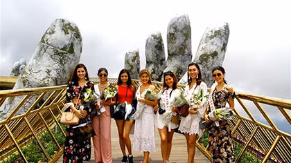 Seven beauty queens “check-in” Vietnam’s famous golden bridge 