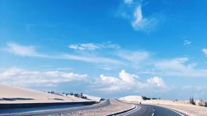 In central Vietnam, a dreamlike road by the blue ocean and white sand dunes
