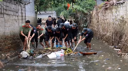Hanoi's police help locals clean up roads after prolonged flooding