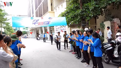 Youth volunteers line up to help administer high school exams