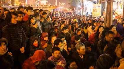 Thousands block Hanoi's main street outside overcrowded pagoda to wish away bad luck