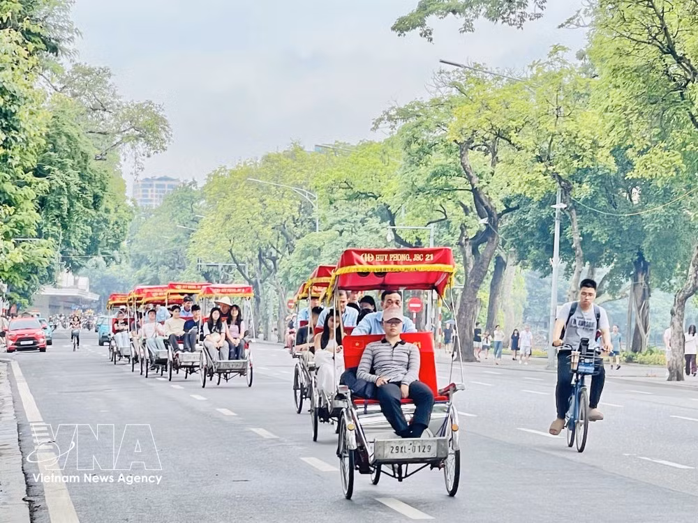 Foreigners tour Hanoi on cyclos (Photo: VNA)