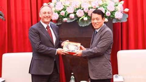 Minister Luong Tam Quang presents a souvenir to Mr. Andrew Cope.