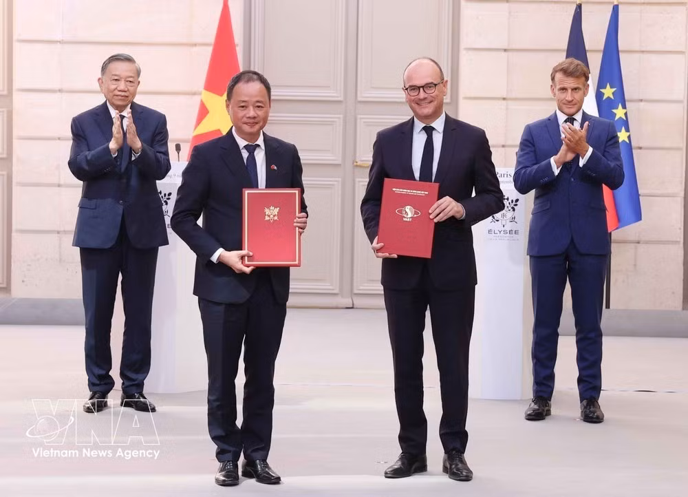 General Secretary of the Communist Party of Vietnam Central Committee and President To Lam and French President Emmanuel Macron witness the exchange of cooperation documents between the two countries. (Photo: VNA)
