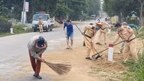 Traffic police clear up stones spilled over on the road