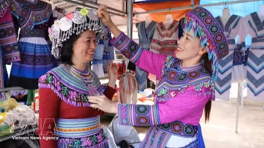 Visitors try on traditional costumes of the Mong ethnic group at Dak R’mang market in Ta Dung commune, Lam Dong province. (Photo: VNA)