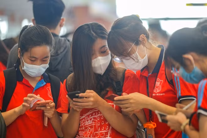 Students complete electronic health declarations before boarding at Noi Bai International Airport.