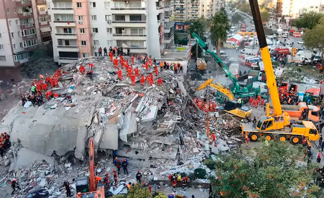 In this photo taken with a drone, members of rescue services search for survivors in the debris of collapsed buildings in Izmir, Turkey. Photo: AP.