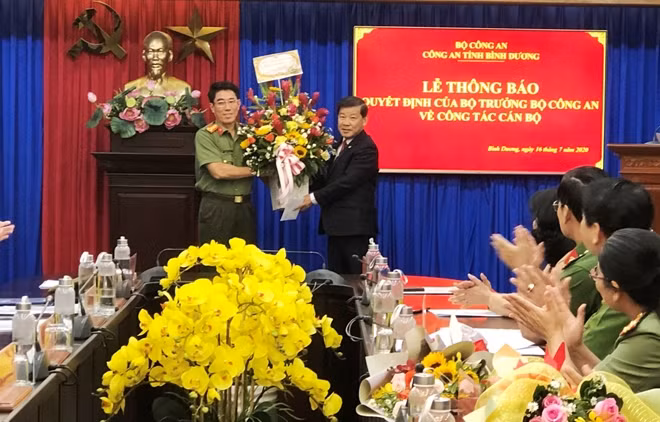 Chairman Tran Thanh Liem presenting flower to Senior Colonel Nguyen Trong Nghia.