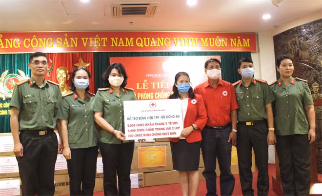 Senior Colonel Ngo Hoai Thu receives anti-pandemic equipment from Mrs. Nguyen Thi Xuan Thu, President of the Vietnam Red Cross.